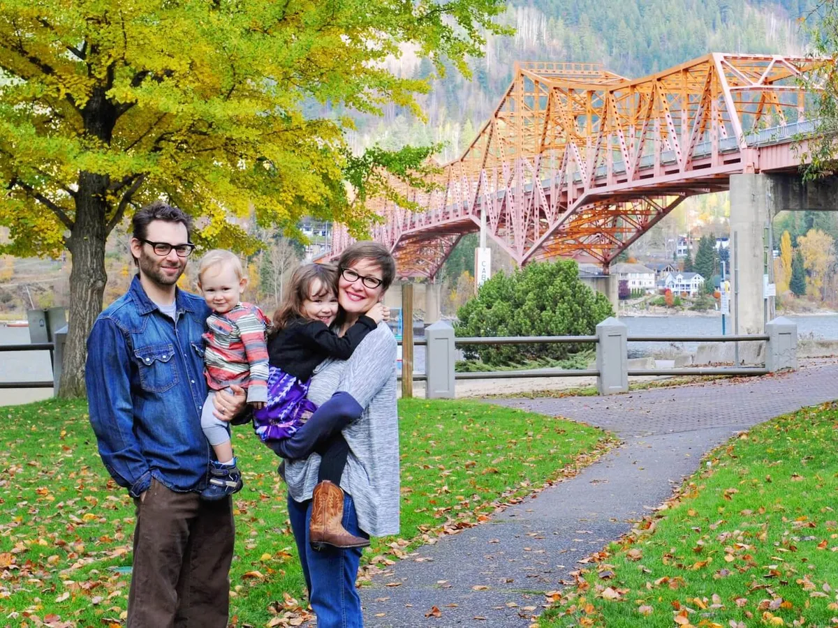 Jess Phillips's family in Nelson in 2016, soon after they moved: her husband holding their toddler son, and Jess holding their young daughter, by the orange bridge